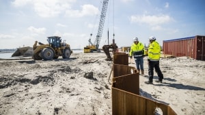 Spunsvæggene er ved at blive installeret omkring den fremtidige tyske tunnelportal for at forsegle udgravningshullet. Stålprofiler drives ned i jorden stykke for stykke. Foto: Femern A/S